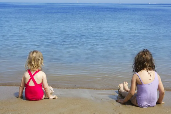 Tow zusters zitten op strand badpak zwembroek — Stockfoto