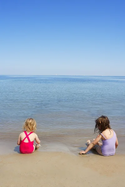 Holowania siostry siedzą na plaży kostium kąpielowy kostium kąpielowy — Zdjęcie stockowe
