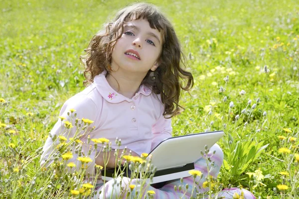 Маленька дівчинка на садовому фоні ноутбук комп'ютер — стокове фото