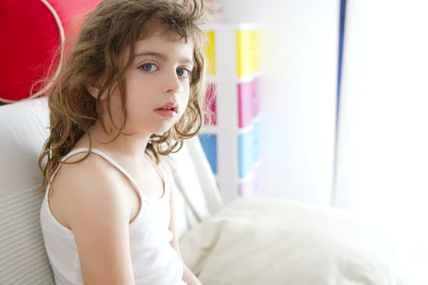 Lilla burnette flicka synd på soffa fönster ljus — Stockfoto