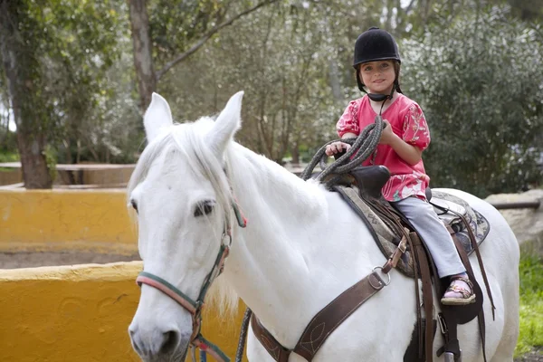 Jeździec dziewczynka dżokej kapelusz biały koń w parku — Zdjęcie stockowe