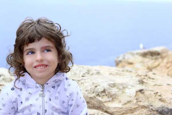 Брюнетка маленькая девочка смешной жест у моря — стоковое фото