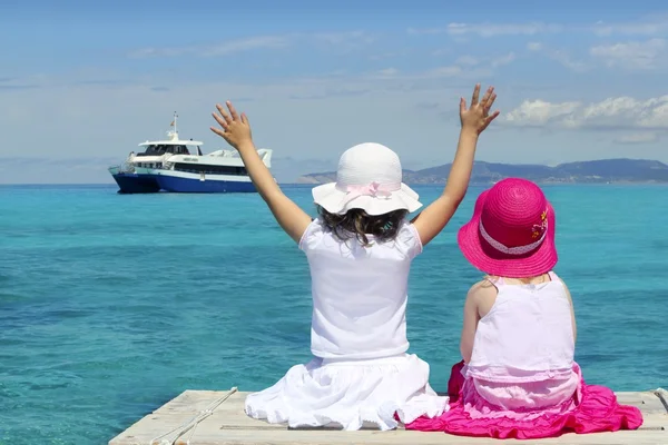 Zwei Mädchen türkisfarbenes Meer zum Abschied Handgeste — Stockfoto
