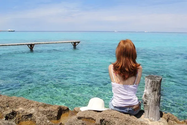 Touristin blickt auf türkisfarbenes Meer — Stockfoto
