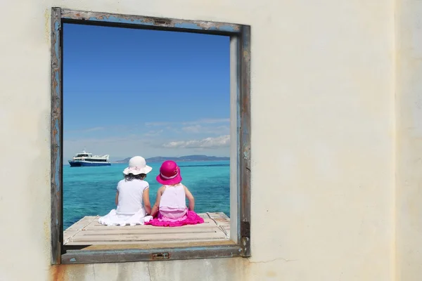 Сёстры смотрят на окно тропической морской бирюзы — стоковое фото