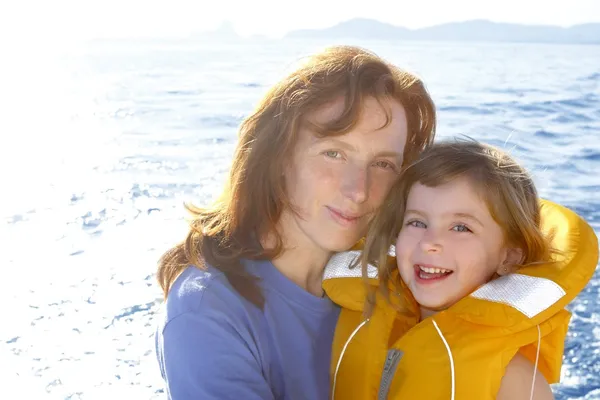 어머니와 딸 안전 조끼 백라이트 바다 — 스톡 사진