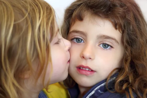 Blond liten tjej kysser hennes dotter blå ögon — Stockfoto