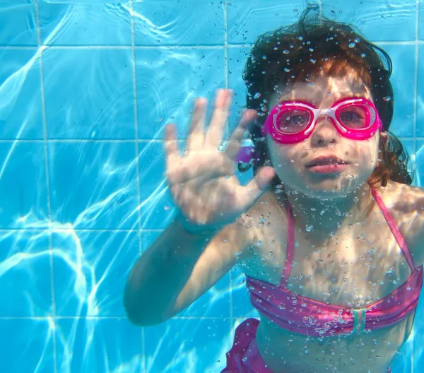 Underwater little girl pink bikini blue swimming pool — Stock Photo, Image