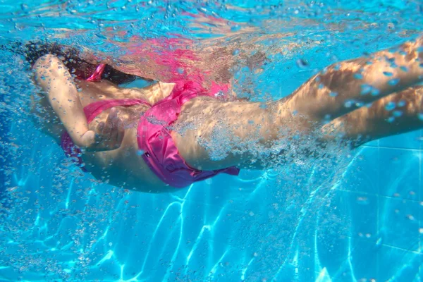 Biquíni rosa subaquático menina nadando na piscina — Fotografia de Stock