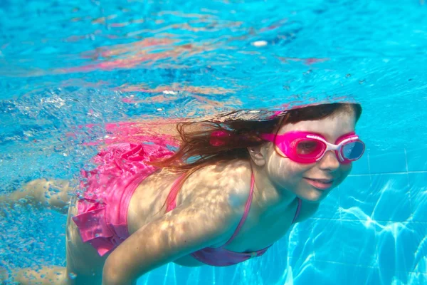 Underwater little girl pink bikini blue swimming pool — Stock Photo, Image