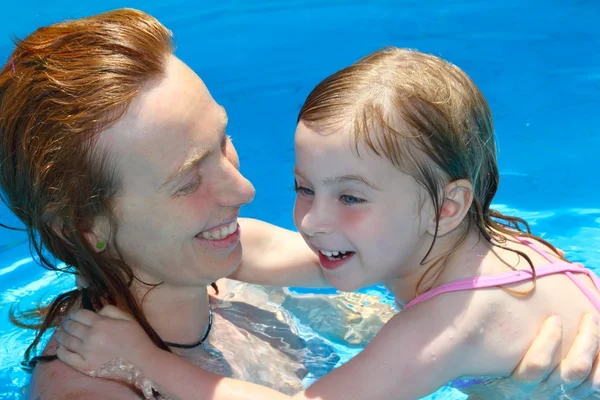 Piscina mãe e filha brincando juntos natação — Fotografia de Stock