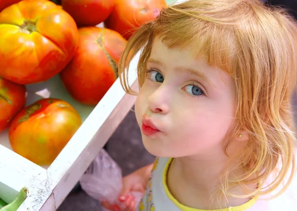 Hungry little girl gesturing in market tomatoes — Stock Photo, Image