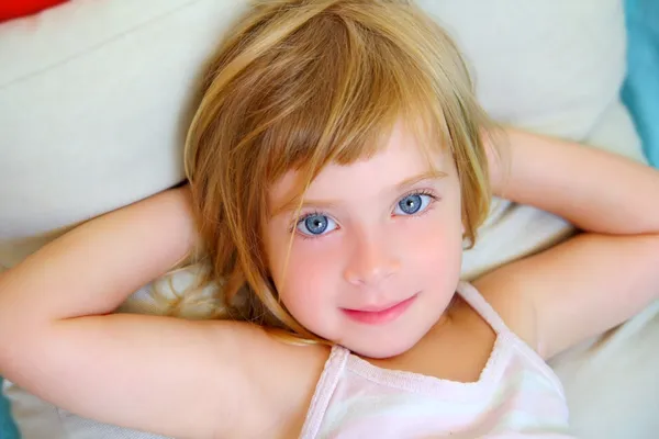Rubia chica relajada en la almohada ojos azules sonriendo — Foto de Stock