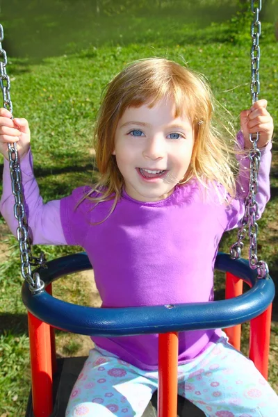Chica balanceándose en swing feliz en prado hierba parque —  Fotos de Stock