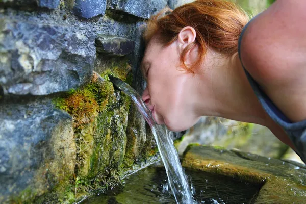 Source of spring water woman drinking — Stock Photo, Image