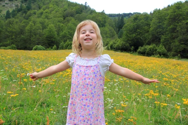 Chica de brazos abiertos en hermoso prado de primavera de flores —  Fotos de Stock