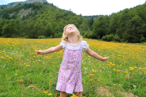 Chica de brazos abiertos en hermoso prado de primavera de flores — Foto de Stock