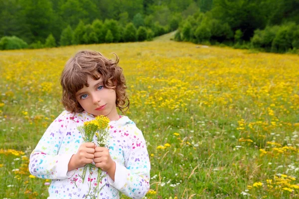 Flicka plockar blommor i gult våren äng — Stockfoto
