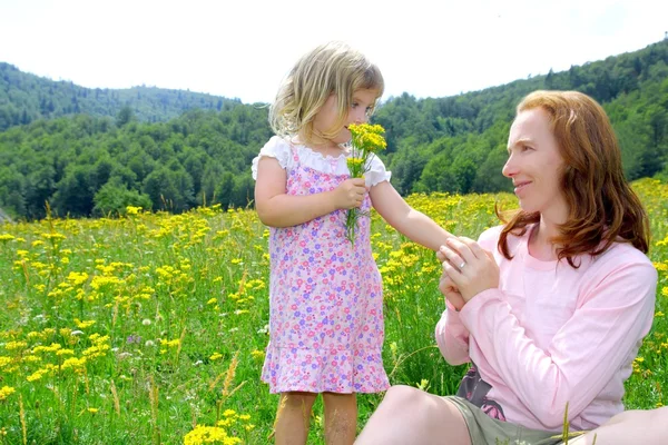 Hija y madre jugando en el prado de flores — Foto de Stock