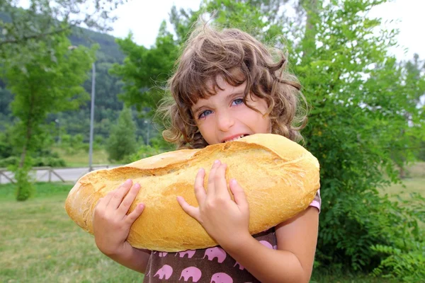 Menina comendo pão grande humor tamanho criança com fome — Fotografia de Stock