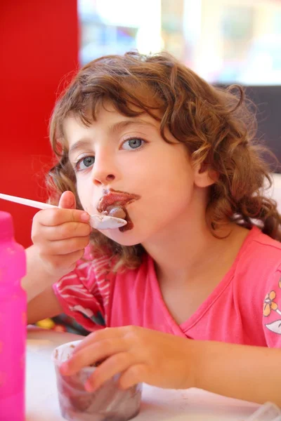 Девушка ест шоколадное мороженое грязное лицо — стоковое фото
