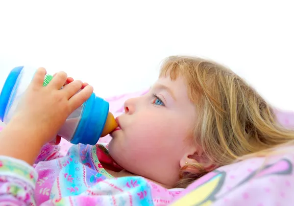 Κορίτσι πίνοντας μπουκάλι γάλα τοποθέτηση στο κρεβάτι — Φωτογραφία Αρχείου