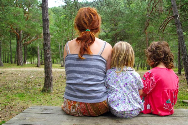 Mother and daughters sitting back park forest — Stock Photo, Image