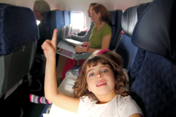 Little girl inside aircraft rising up finger — Stock Photo, Image