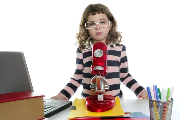 Студентка маленькая девочка с микроскопом и ноутбуком — стоковое фото