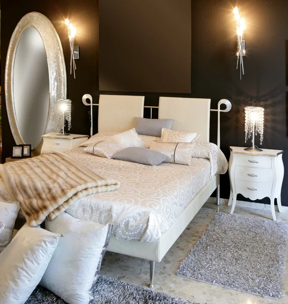Sovrum modernt silver oval spegel vit säng Stockbild