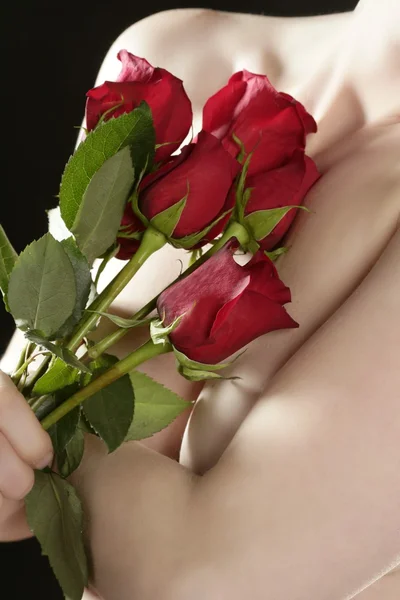 Romantische nackte Frau mit roten Rosen Stockbild