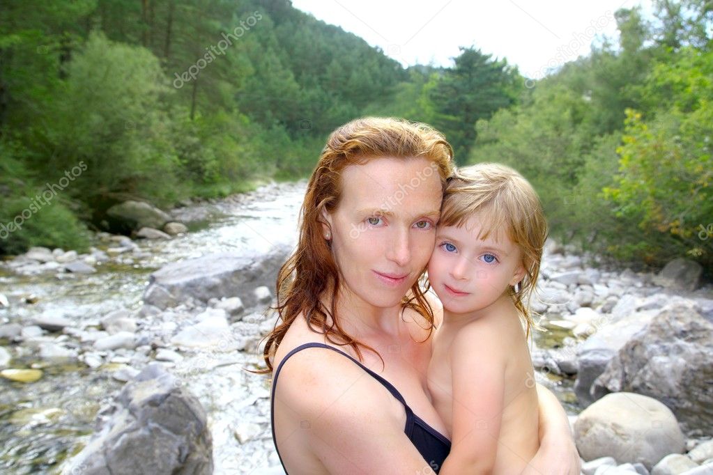 Mother daughter playing in river after swimming