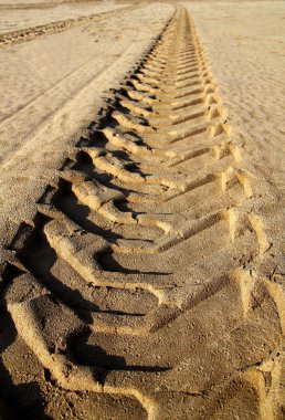 Tractor tires pneus footprint printed on beach sand clipart