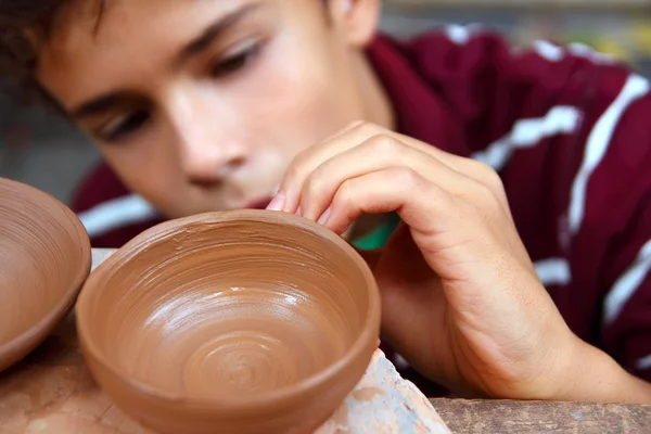Niño alfarero adolescente tazón de arcilla trabajando en taller de cerámica — Foto de Stock
