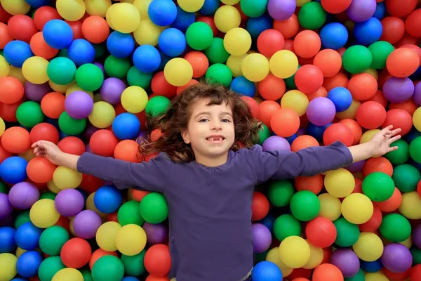 Colorful balls funny park little girl lying gesturing — Stock Photo, Image