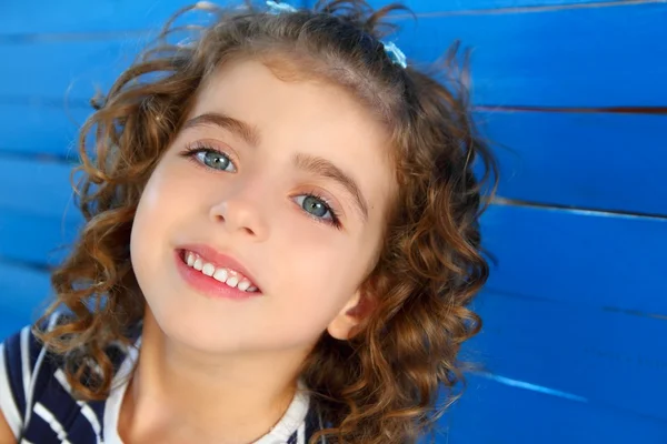 Děti malá holka s úsměvem na dřevěné modré zdi — Stock fotografie