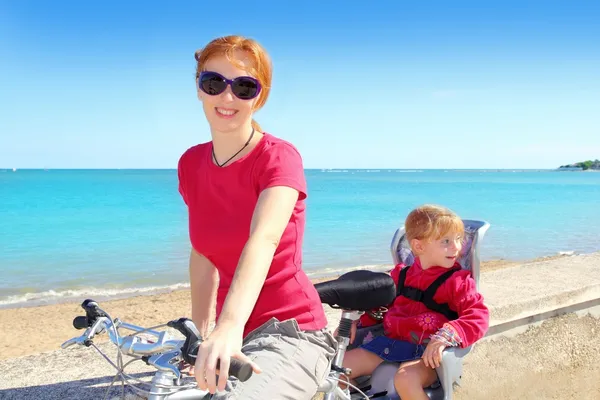 Filha e mãe de bicicleta no mar de praia — Fotografia de Stock