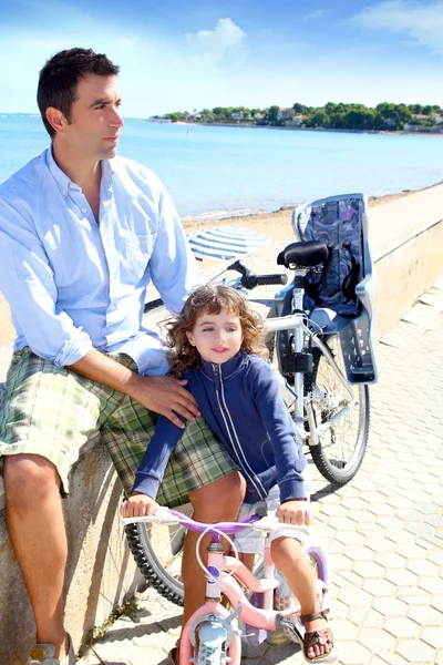 Dotter och far på cykel i stranden havet — Stockfoto