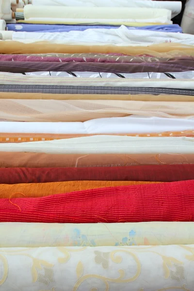 Rolos de tecido de moda na loja de varejo em uma fileira — Fotografia de Stock