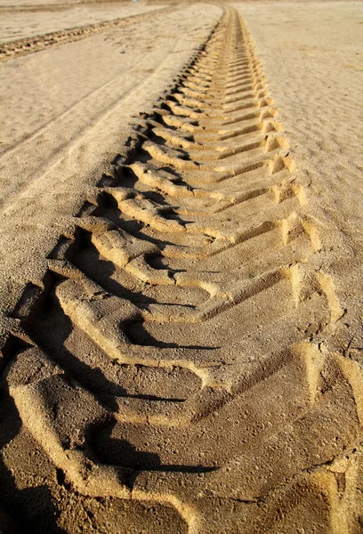 Tractor neumáticos huella de pneus impreso en arena de playa — Foto de Stock