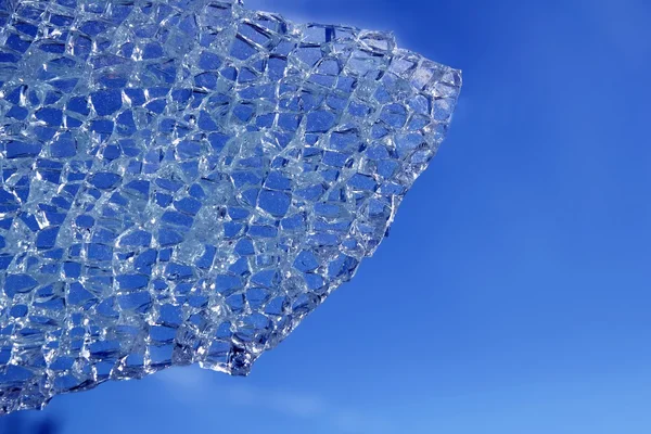 Gebroken glas gekraakt over blauwe achtergrond — Stockfoto