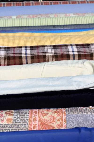Fabric rolls in a row focus in foreground — Stock Photo, Image