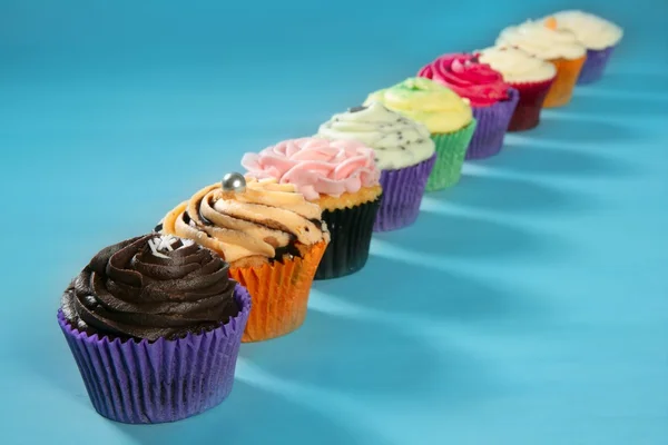 Uspořádání barevných krém muffin košíčky — Stock fotografie