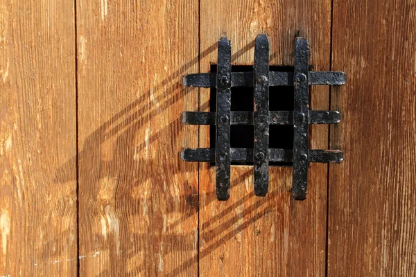 Ancient window black metal jail grid wooden door — Stock Photo, Image