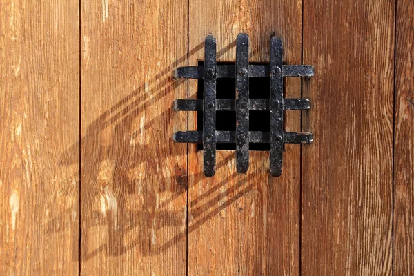 Ancient window black metal jail grid wooden door — Stock Photo, Image