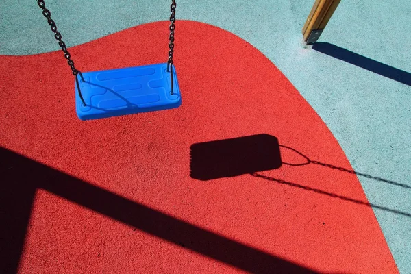 Mavi park swing veya kırmızı zemin çocuk oyun alanı — Stok fotoğraf