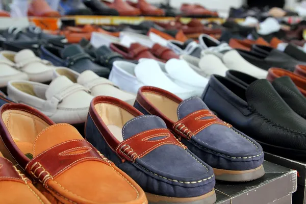 Sapatos de couro loja de varejo em linhas de cores variadas — Fotografia de Stock
