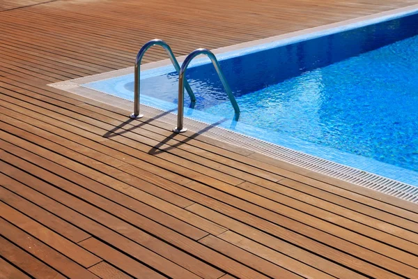 Голубой бассейн с деревянным напольным покрытием — стоковое фото