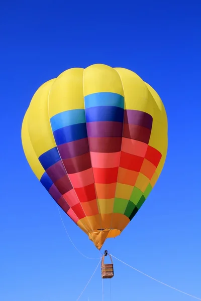 Μπαλόνι πολύχρωμο έντονα χρώματα, σε γαλάζιο ουρανό — Φωτογραφία Αρχείου