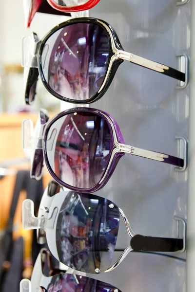 Сонцезахисні окуляри сонцезахисні окуляри складені ряд в дисплеї магазину — стокове фото